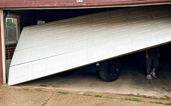 Partially open garage door with visible vehicle inside.