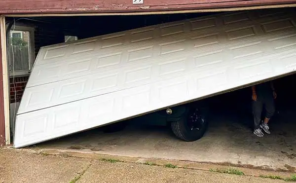 Partially open garage door with visible vehicle inside.