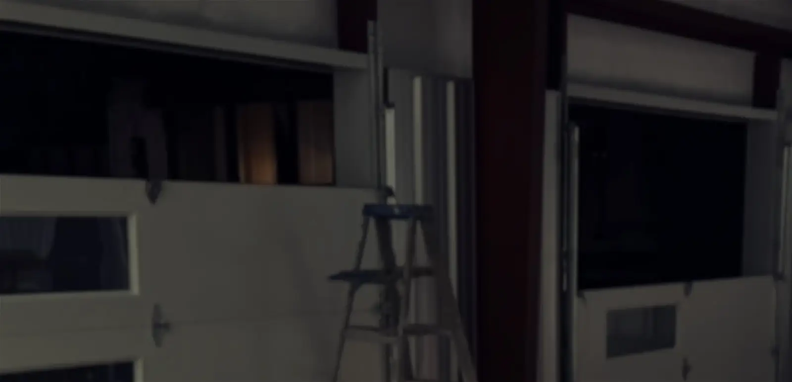 Indoor garage with ladder and doors.