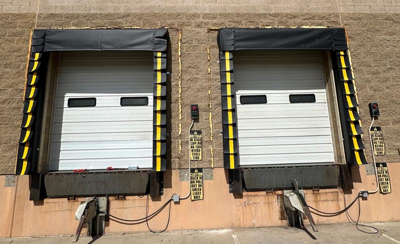 Loading dock with closed doors and safety signs.