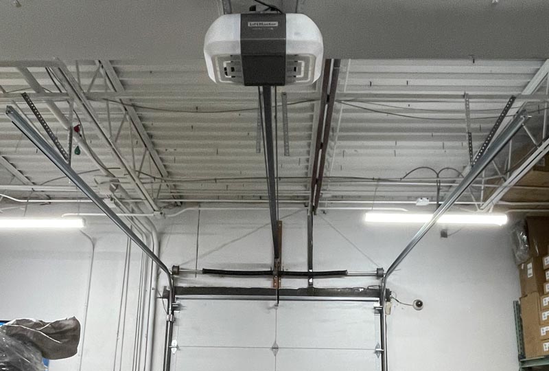 Ceiling-mounted garage door opener in a warehouse.