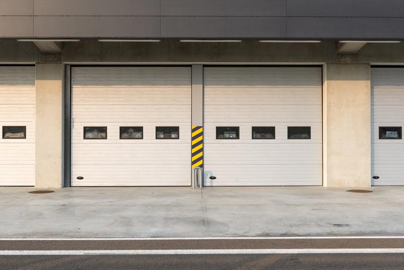 Closed garage doors on concrete building exterior.