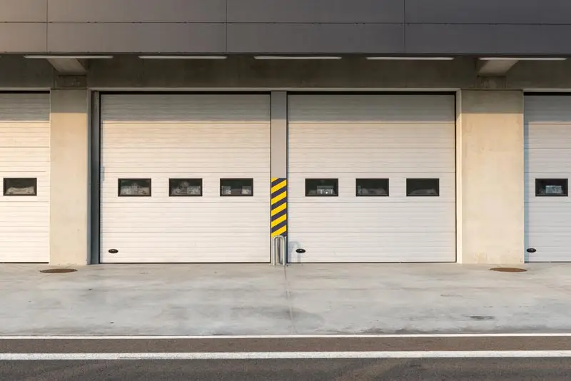 Closed garage doors on concrete building exterior.