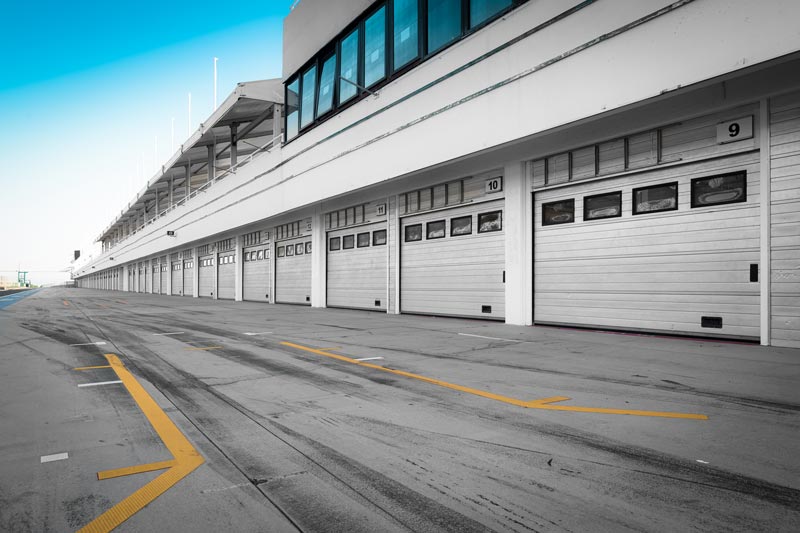 Empty race track garage bays with closed doors.