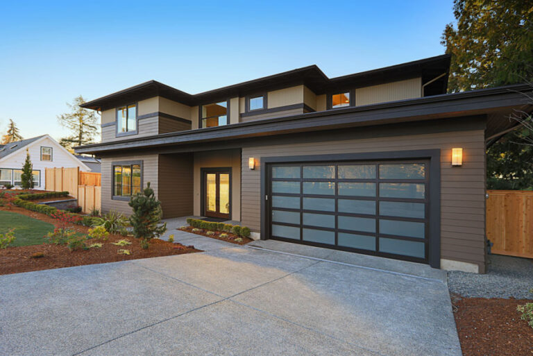 Modern two-story house with large garage doors.