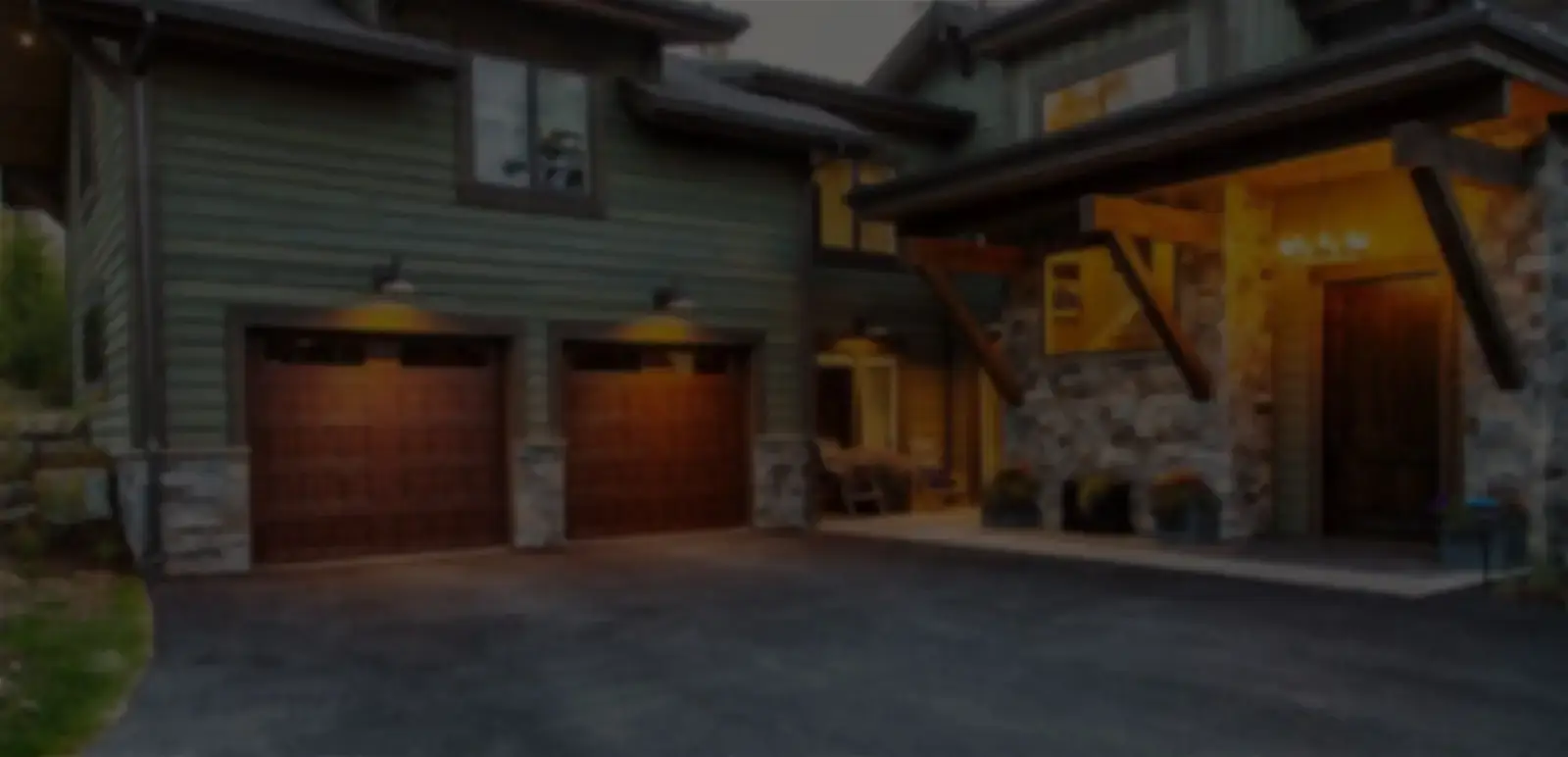 Cozy house exterior with garage and porch lighting.