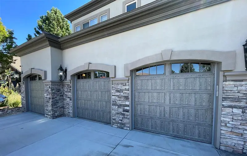 Triple garage with stone and wood doors.