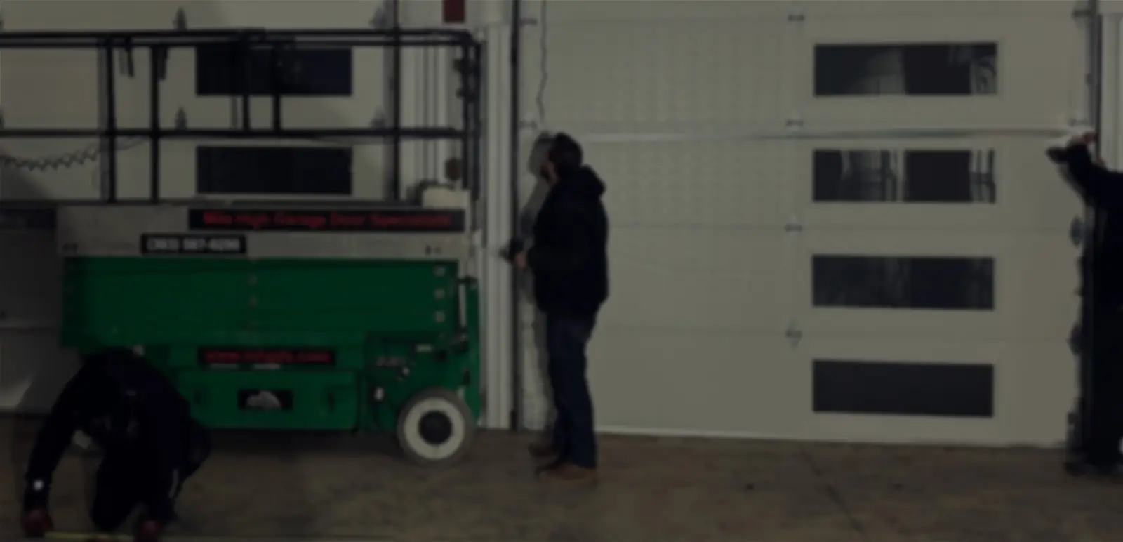 Technician inspecting industrial garage door equipment.