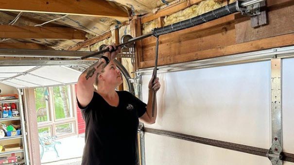 Person repairing garage door mechanism.