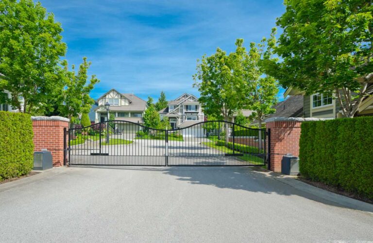 Gated residential neighborhood with brick pillars and trees.