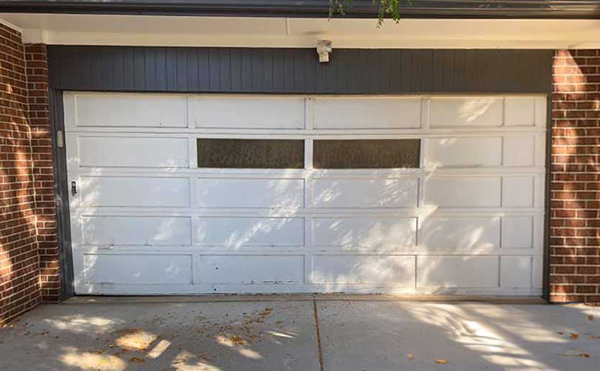 White garage door with brick walls.