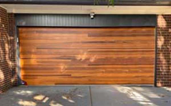 Wooden garage door with brick frame