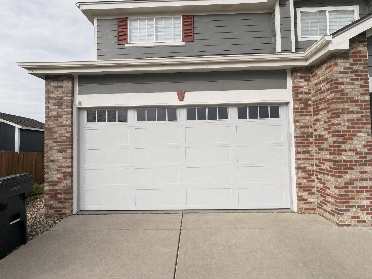 Same garage door photographed on an overcast day with even flat light, square angle, and roof line and driveway both in the frame